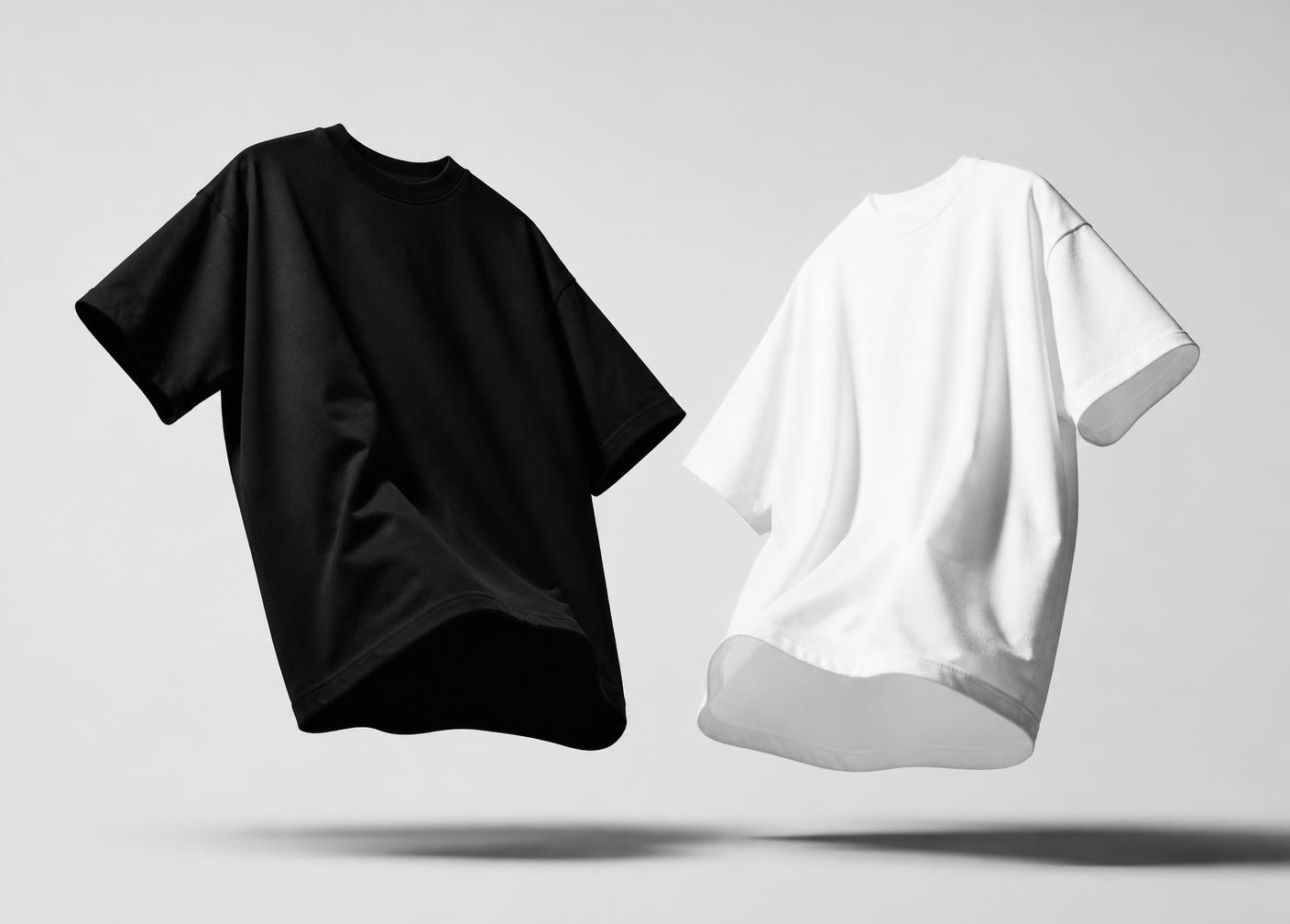 Blank black and white t-shirts floating on a light studio background